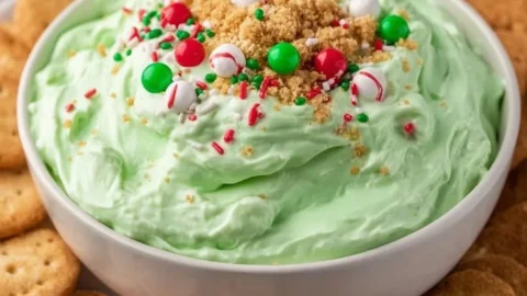 Festive Grinch Dip served in a holiday-themed bowl
