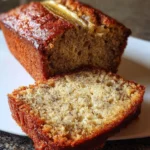 Slice of moist and fluffy banana bread on a wooden table