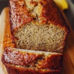 Perfect moist banana bread loaf with sliced pieces on a wooden table